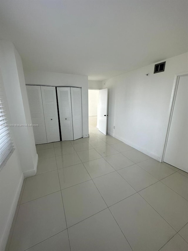 850 N Miami Ave Unit W-2003, Miami, FL 33136 - unfurnished bedroom with baseboards, light tile patterned flooring, and a closet