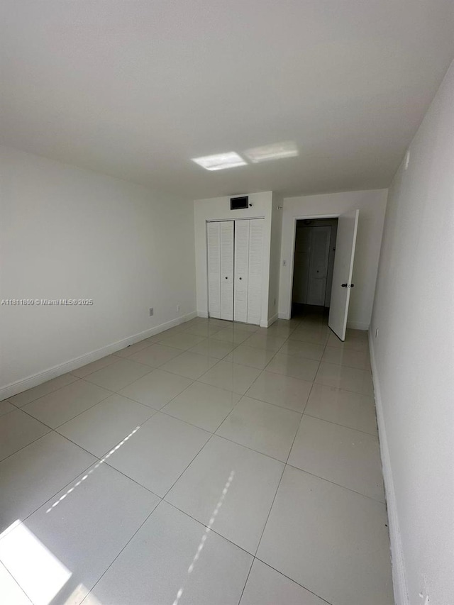850 N Miami Ave Unit W-2003, Miami, FL 33136 - unfurnished bedroom featuring light tile patterned floors, baseboards, and a closet