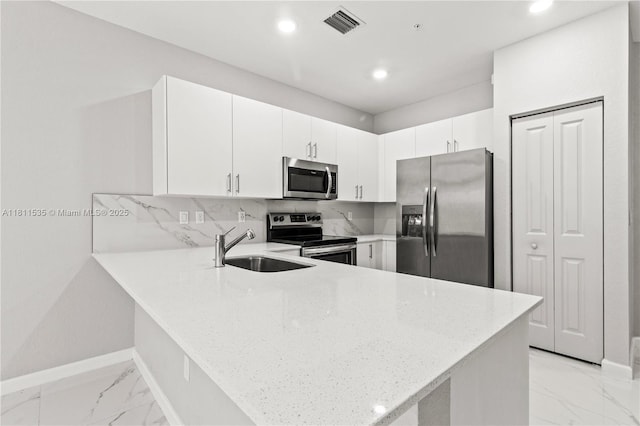 221 SW 159th Way, Pembroke Pines, FL 33027 - kitchen with appliances with stainless steel finishes, a sink, a peninsula, light marble finish floors, and light stone counters