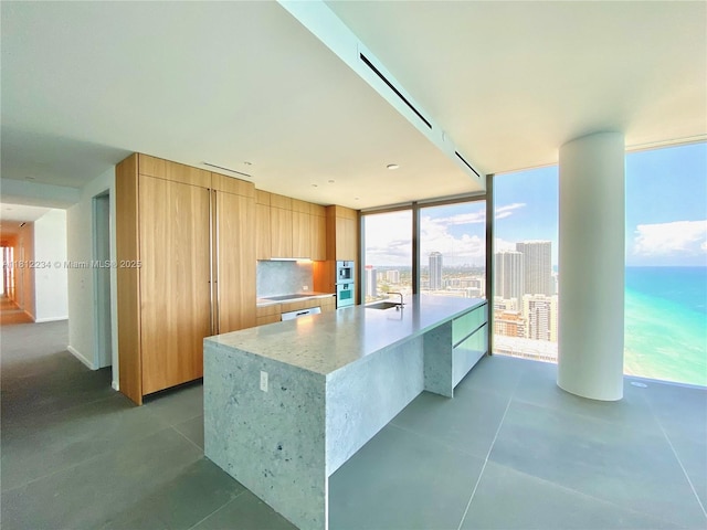 2000 S Ocean Dr Unit 33A, Hallandale Beach, FL 33009 - kitchen with modern cabinets, a sink, light stone countertops, dark tile patterned flooring, and floor to ceiling windows