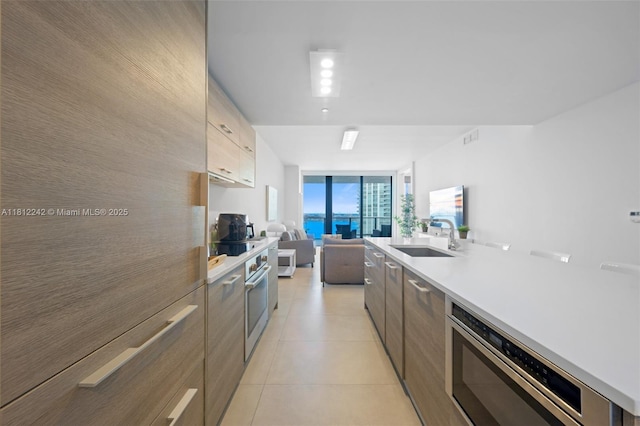 650 NE 32nd St Unit 2502, Miami, FL 33137 - kitchen with modern cabinets, stainless steel microwave, open floor plan, light countertops, and floor to ceiling windows