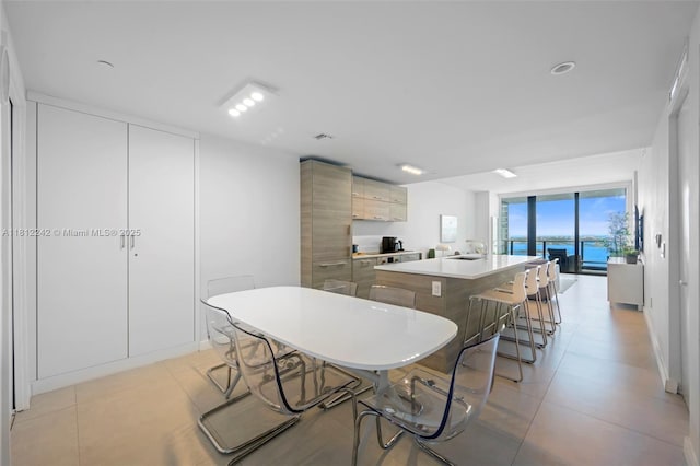 650 NE 32nd St Unit 2502, Miami, FL 33137 - kitchen featuring modern cabinets, a center island with sink, a breakfast bar area, light countertops, and light tile patterned floors