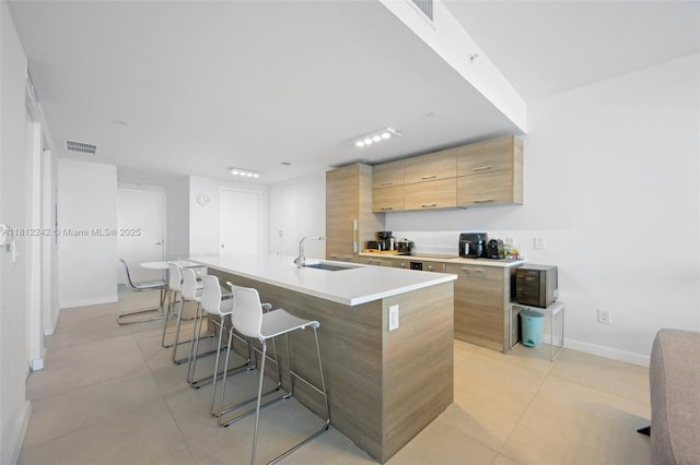 650 NE 32nd St Unit 2502, Miami, FL 33137 - kitchen with a kitchen breakfast bar, an island with sink, modern cabinets, light tile patterned floors, and light countertops