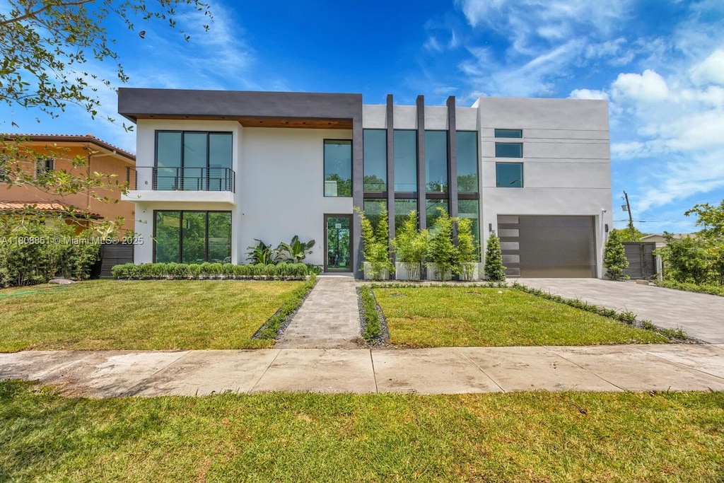 4231 SW 11th St, Miami, FL 33134 - contemporary home featuring stucco siding, driveway, a front lawn, a balcony, and an attached garage