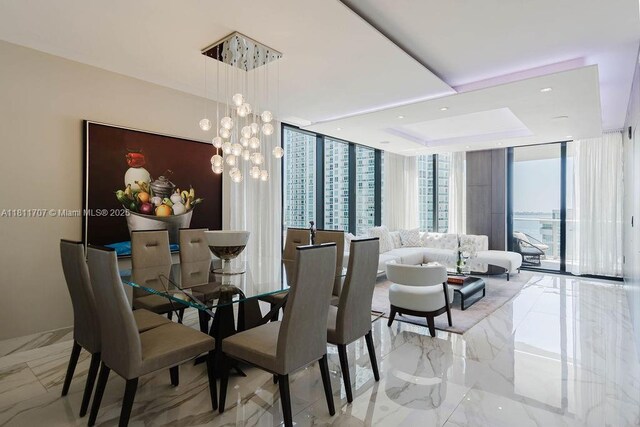 1010 Brickell Ave Unit 1501, Miami, FL 33131 - dining space with expansive windows, marble tiled flooring, a chandelier, recessed lighting, and a tray ceiling