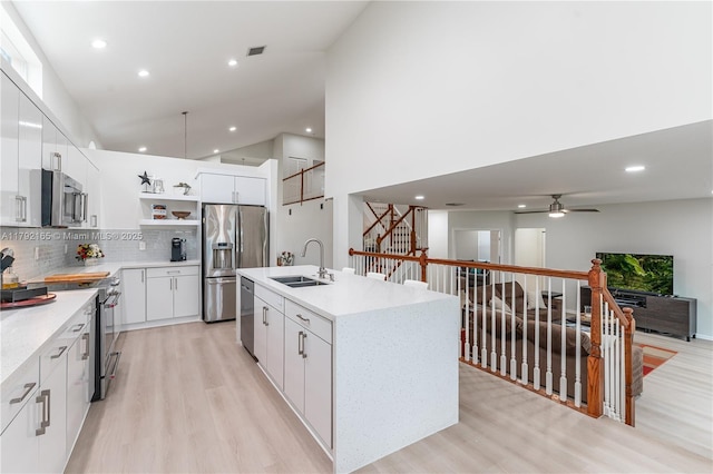 5064 SW 164th Ave, Miramar, FL 33027 - kitchen featuring a sink, open shelves, appliances with stainless steel finishes, light wood finished floors, and tasteful backsplash