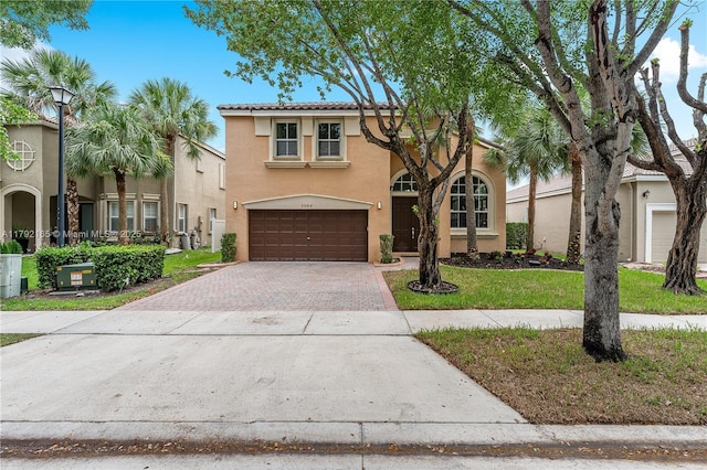 5064 SW 164th Ave, Miramar, FL 33027 - mediterranean / spanish-style house featuring stucco siding, decorative driveway, an attached garage, a tiled roof, and a front yard