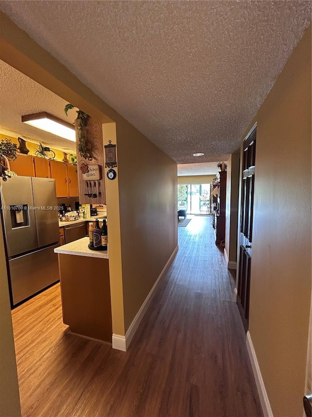 9577 W Mcnab Rd Unit 110, Tamarac, FL 33321 - hall featuring a textured ceiling, wood finished floors, and baseboards
