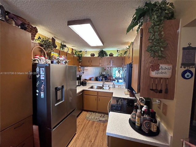 9577 W Mcnab Rd Unit 110, Tamarac, FL 33321 - kitchen with stainless steel refrigerator with ice dispenser, a sink, light countertops, stove, and light wood-style floors
