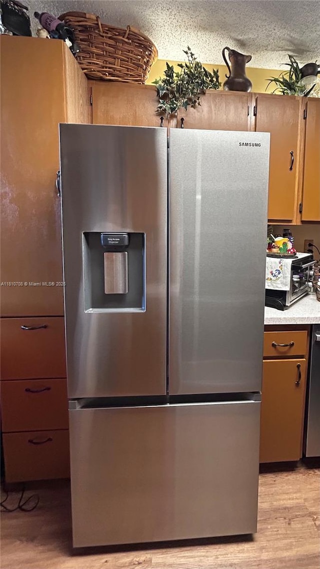 9577 W Mcnab Rd Unit 110, Tamarac, FL 33321 - kitchen featuring appliances with stainless steel finishes, light countertops, light wood-style flooring, and a textured ceiling