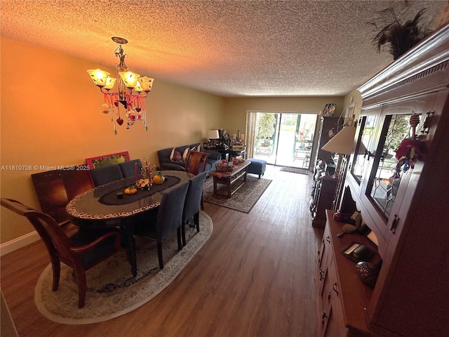 9577 W Mcnab Rd Unit 110, Tamarac, FL 33321 - dining space featuring a textured ceiling, a chandelier, and wood finished floors
