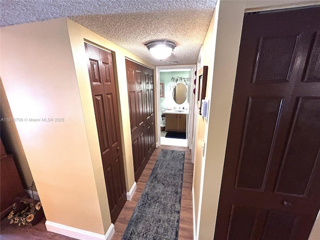 9577 W Mcnab Rd Unit 110, Tamarac, FL 33321 - hall featuring wood finished floors, a textured ceiling, and baseboards