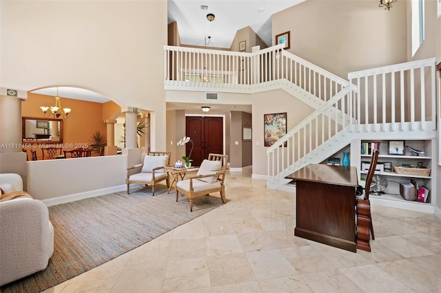 8205 SW 171st Ter, Palmetto Bay, FL 33157 - living area with a chandelier, marble finish flooring, stairway, a towering ceiling, and arched walkways