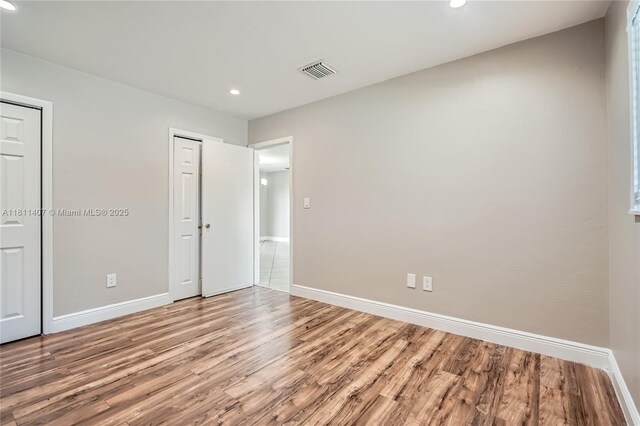 20701 Eagle Nest Rd, Cutler Bay, FL 33189 - unfurnished bedroom featuring wood finished floors, baseboards, recessed lighting, and two closets