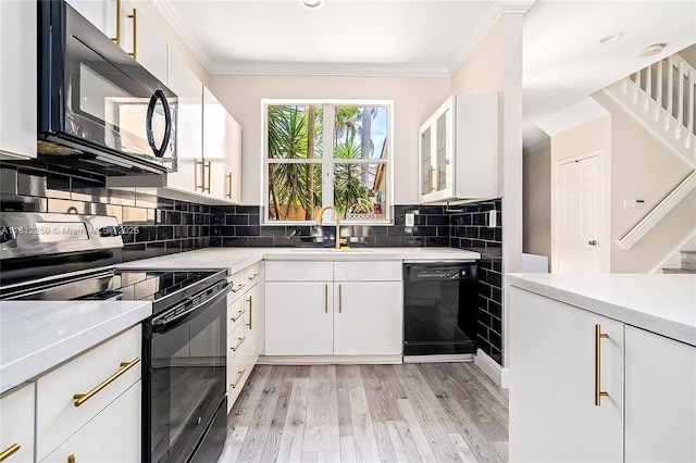 21024 NE 34th Ct, Aventura, FL 33180 - kitchen with black appliances, a sink, light countertops, crown molding, and light wood-style flooring