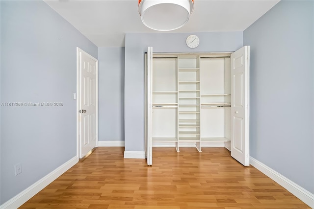 21024 NE 34th Ct, Aventura, FL 33180 - unfurnished bedroom featuring light wood-style flooring, a closet, and baseboards
