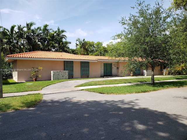 1240 La Mancha Ave, Coral Gables, FL 33134 - view of front of home featuring stucco siding, a front yard, and a tile roof