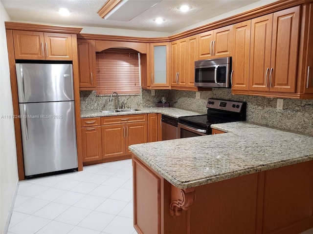 1240 La Mancha Ave, Coral Gables, FL 33134 - kitchen featuring stainless steel appliances, a sink, light stone counters, brown cabinets, and recessed lighting