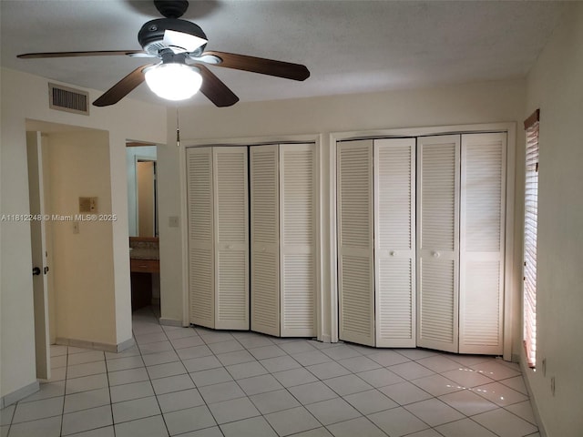 1240 La Mancha Ave, Coral Gables, FL 33134 - unfurnished bedroom featuring two closets, light tile patterned floors, and a ceiling fan