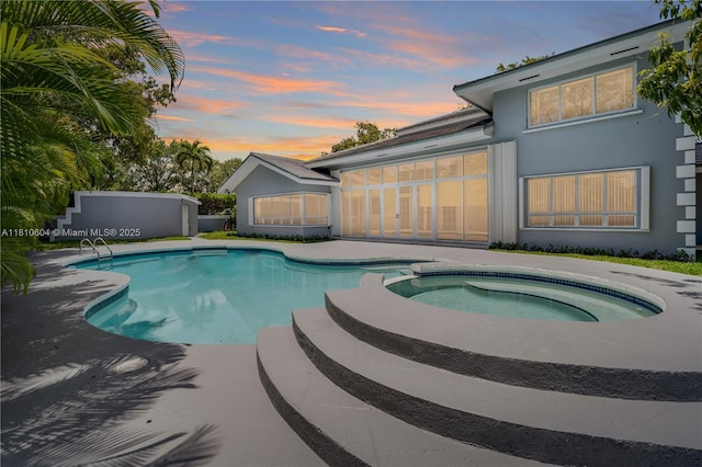 7201 SW 84th Pl, Miami, FL 33143 - pool at dusk with a pool with connected hot tub, a patio area, and a sunroom