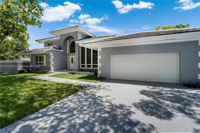 7201 SW 84th Pl, Miami, FL 33143 - view of front facade featuring stucco siding, driveway, a front lawn, and an attached garage