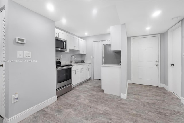 469 NE 207th Ln Unit 205, Miami, FL 33179 - kitchen featuring appliances with stainless steel finishes, light countertops, baseboards, white cabinets, and a sink