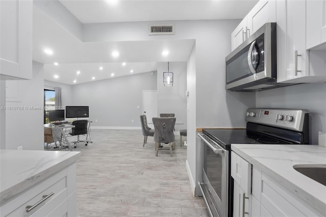 469 NE 207th Ln Unit 205, Miami, FL 33179 - kitchen with stainless steel appliances, white cabinets, light stone countertops, and recessed lighting