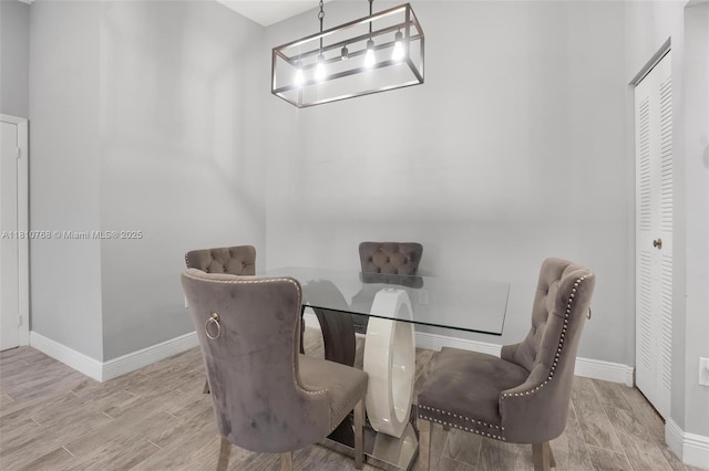 469 NE 207th Ln Unit 205, Miami, FL 33179 - dining space featuring baseboards, wood finished floors, and a chandelier
