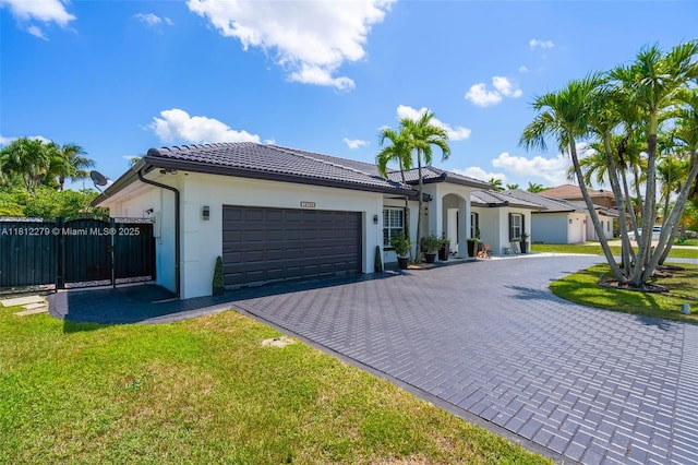 15760 SW 45th St, Miami, FL 33185 - mediterranean / spanish-style home featuring a garage, decorative driveway, stucco siding, a tiled roof, and a gate