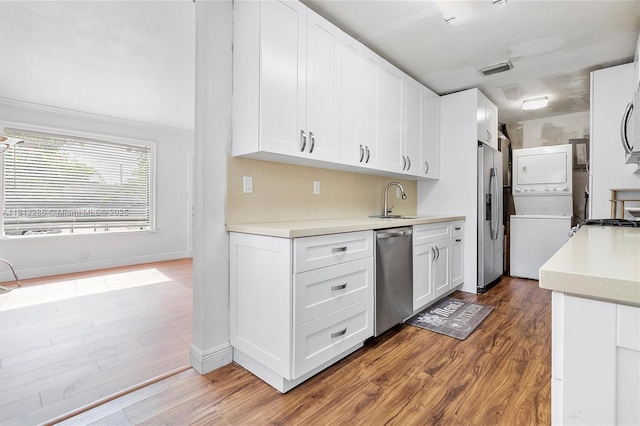 840 N 68th Ter, Hollywood, FL 33024 - kitchen with stacked washing machine and dryer, appliances with stainless steel finishes, wood finished floors, and light countertops