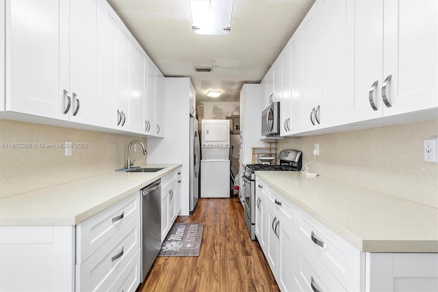 840 N 68th Ter, Hollywood, FL 33024 - kitchen with stainless steel appliances, a sink, stacked washer / drying machine, wood finished floors, and light countertops