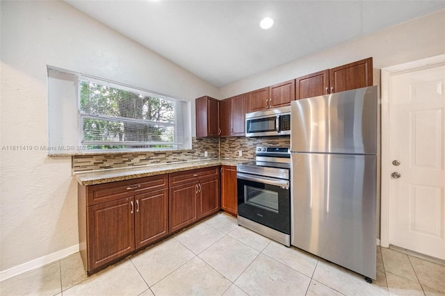 501 Carolina Ave, Fort Lauderdale, FL 33312 - kitchen featuring appliances with stainless steel finishes, tasteful backsplash, light tile patterned floors, baseboards, and light stone countertops