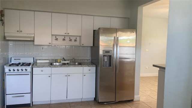 3351 SW 28th St, Miami, FL 33133 - kitchen featuring stainless steel fridge, white gas stove, under cabinet range hood, a sink, and light tile patterned flooring