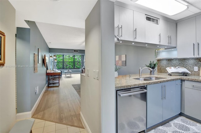 1709 Whitehall Dr Unit 401, Davie, FL 33324 - kitchen featuring stainless steel dishwasher, a sink, light stone countertops, baseboards, and decorative backsplash