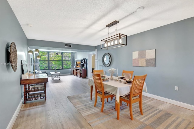 1709 Whitehall Dr Unit 401, Davie, FL 33324 - dining room featuring a textured ceiling, wood finished floors, and baseboards