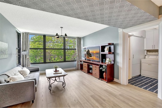1709 Whitehall Dr Unit 401, Davie, FL 33324 - living area with washer / dryer, light wood finished floors, baseboards, and a chandelier
