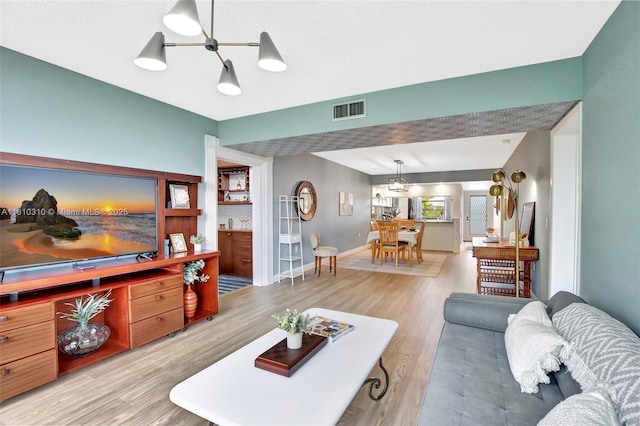1709 Whitehall Dr Unit 401, Davie, FL 33324 - living room with light wood finished floors, a chandelier, and baseboards