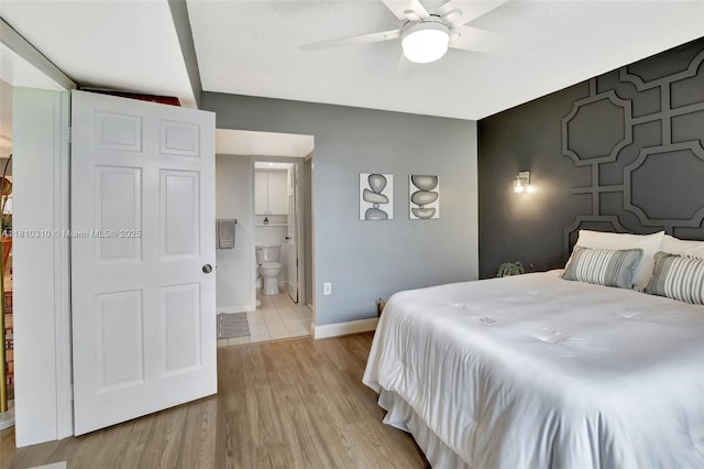 1709 Whitehall Dr Unit 401, Davie, FL 33324 - bedroom featuring an accent wall, baseboards, light wood-type flooring, ensuite bathroom, and a ceiling fan
