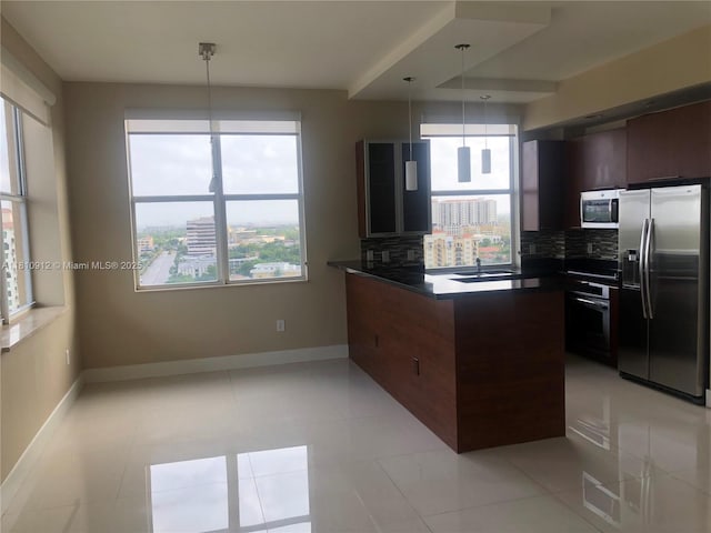 1607 Ponce De Leon Blvd Unit 12E, Coral Gables, FL 33134 - kitchen with appliances with stainless steel finishes, a peninsula, dark countertops, and baseboards