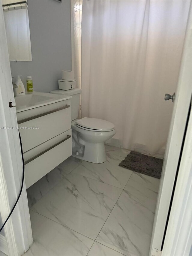 3297 W 70th St, Hialeah, FL 33018 - bathroom with marble finish flooring, vanity, and toilet