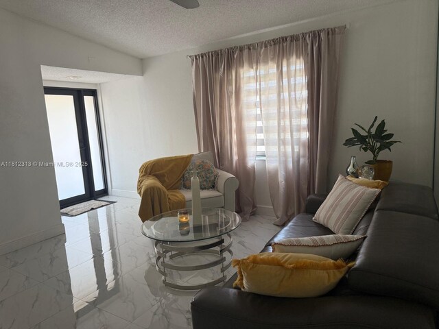 3297 W 70th St, Hialeah, FL 33018 - living room with marble finish floors, a textured ceiling, and baseboards