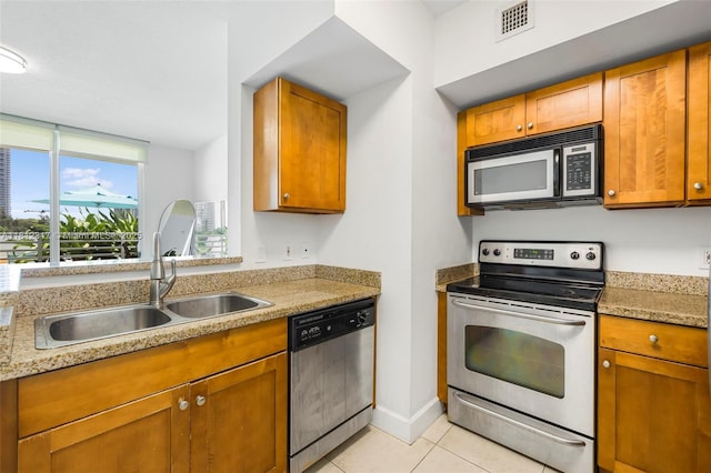 1723 SW 2nd Ave Unit 502, Miami, FL 33129 - kitchen featuring stainless steel appliances, light tile patterned floors, brown cabinetry, and light countertops