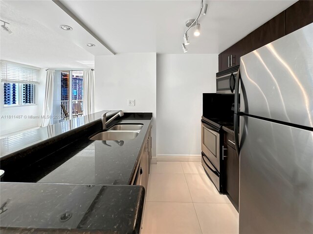 850 N Miami Ave Unit W-1903, Miami, FL 33136 - kitchen with stainless steel appliances, a sink, dark stone countertops, light tile patterned floors, and baseboards