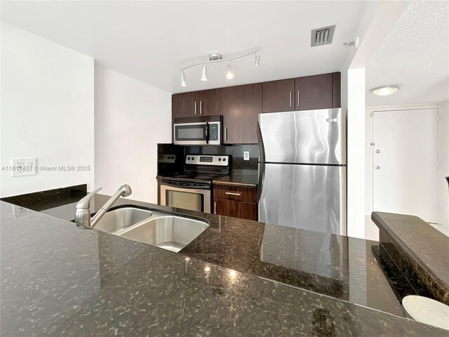 850 N Miami Ave Unit W-1903, Miami, FL 33136 - kitchen featuring stainless steel appliances, a sink, dark stone countertops, and dark brown cabinets