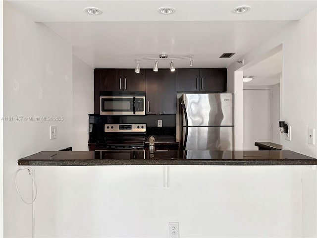 850 N Miami Ave Unit W-1903, Miami, FL 33136 - kitchen featuring stainless steel appliances, dark countertops, dark brown cabinets, track lighting, and a peninsula