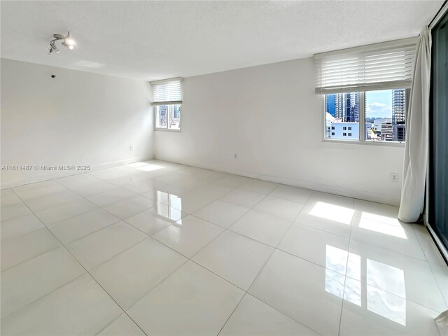 850 N Miami Ave Unit W-1903, Miami, FL 33136 - empty room featuring a textured ceiling, light tile patterned floors, and baseboards