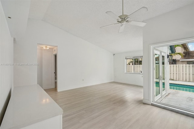 731 Briarwood Ter, Davie, FL 33325 - spare room featuring lofted ceiling, light wood-style flooring, ceiling fan, a textured ceiling, and baseboards