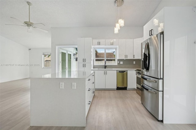 731 Briarwood Ter, Davie, FL 33325 - kitchen with appliances with stainless steel finishes, light wood-type flooring, a sink, white cabinetry, and light countertops