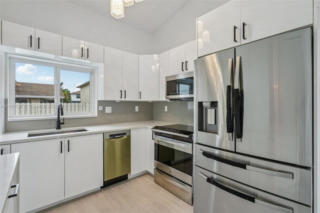 731 Briarwood Ter, Davie, FL 33325 - kitchen with appliances with stainless steel finishes, a sink, light countertops, white cabinetry, and light wood-type flooring