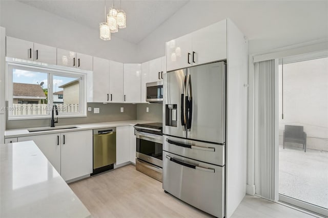 731 Briarwood Ter, Davie, FL 33325 - kitchen featuring stainless steel appliances, a sink, light countertops, white cabinetry, and a chandelier